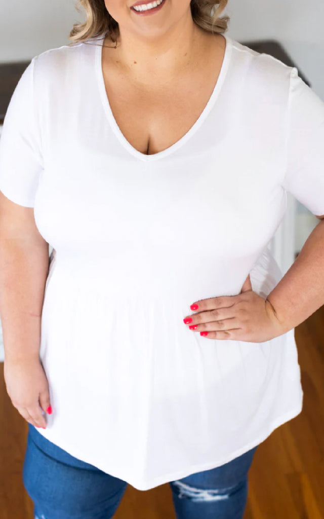Woman wearing a white babydoll short sleeve top.