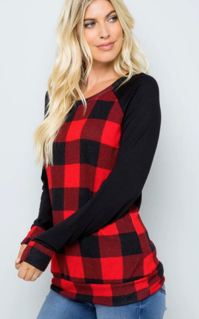 Woman wearing a raglan style shirt in a buffalo plaid print.