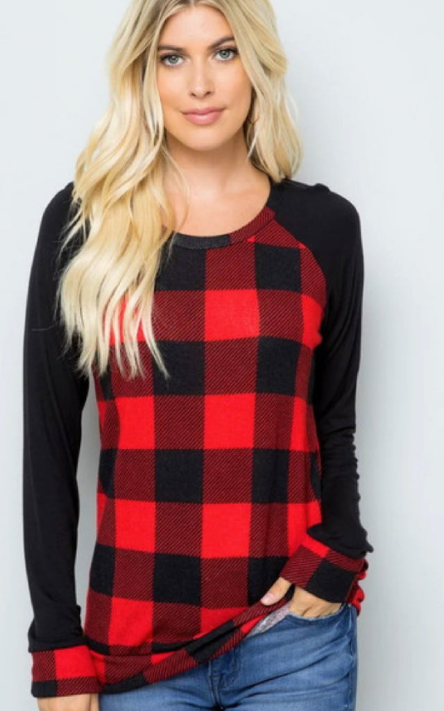 Woman wearing a raglan style shirt in a buffalo plaid print.